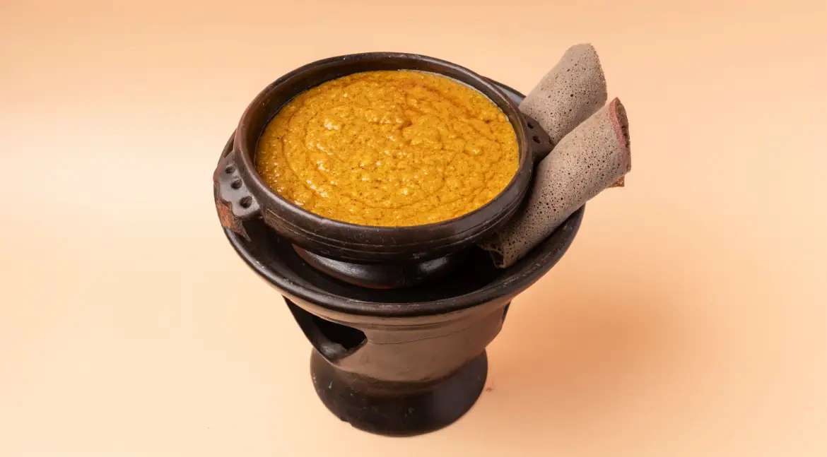 Shiro – cremiges Kichererbsenpüree mit Berbere – im schwarzen Tontopf, dazu gerollte Injera