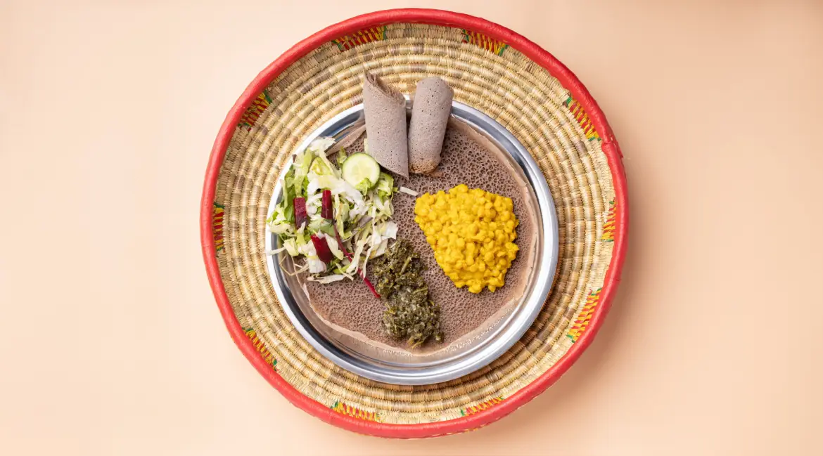 Injera-Teller mit Misir Wat (roten Linsen), Gomen und frischem Salat